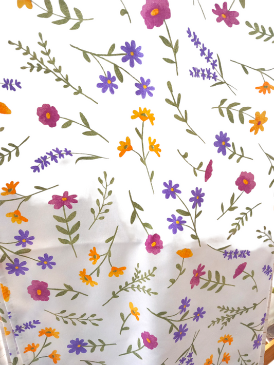 Tovaglia in cotone con fiori multicolor, disponibile in diverse misure.